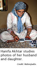 Hanifa Akhtar studies photos of her family.