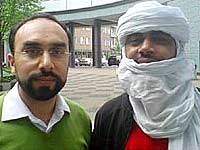 Heart and Soul presenter Navid Akhtar with Abdullah Ag Alhousseyni, a North African Tuareg man wearing a headscarf that covers all of his head except for his face from the eyebrows down to the mouth