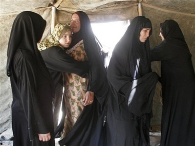Iraqi policewomen search female Shiite pilgrims as they make ...
