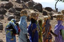 In this image provided by Physicians for Human Rights, Darfuri women return to a