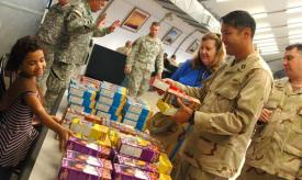 [Alexandria Ramseier, a Brownie with the Girl Scouts of Guantanamo Bay Troop, helps a Joint Task Force Guantanamo Trooper pick out cookies at the Seaside Galley, July 2. Ramseier and other Girl Scouts spent two days handing out donated cookies. (JTF Guantanamo photo by Navy Petty Officer 1st Class Richard M. Wolff, 2 July 2009)
]