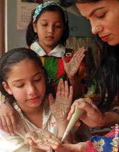 Girl watching woman paint another girls hand (AP Images)