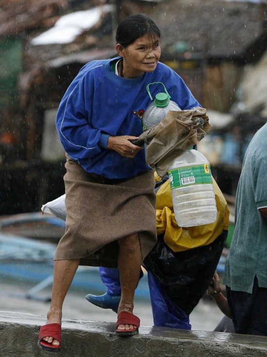 A Filipino woman braves strong winds during typhoon in the town of Bacoor, Cavite province, Philippines on 31 October 2009. At least five people were killed as a powerful typhoon on 31 October hit several provinces in the Philippines, triggering flashfloods, landslides and widespread power outages, officials said. Hundreds of houses in shore areas were swept away by huge waves when Typhoon Mirinae hit land. Mirinae pummelled the country three weeks after back-to-back storms wreaked havoc in Manila and the northern provinces, killing nearly 1,000 people and affecting more than 8 million.  EPA/FRANCIS R. MALASIG
