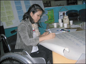 Image of  a vietnamese woman in a wheelchair, working 
