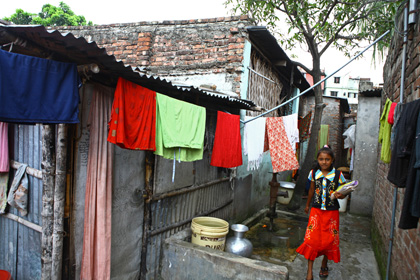 Girl student stands outside the Child Learning Centre in Sheorapara