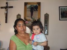 Paula Flores and a grandchild, next to a photo of her murdered daughter Sagrario. / Credit:Daniela Pastrana/IPS 