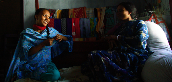 Two women from Bangladesh talking on a sofa