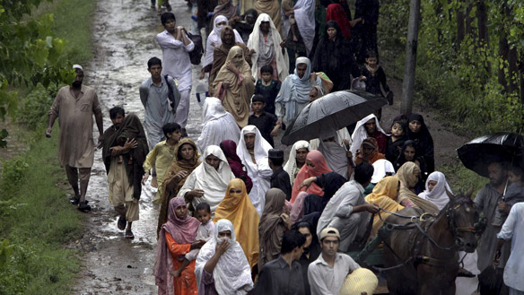 Villagers move to safety from a flooded village near Nowshera, in Pakistan's Khyber-Pakhtoonkhwa province, on Thursday. 