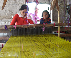 Members of Manipur Women Gun Survivors Network weaving at a loom