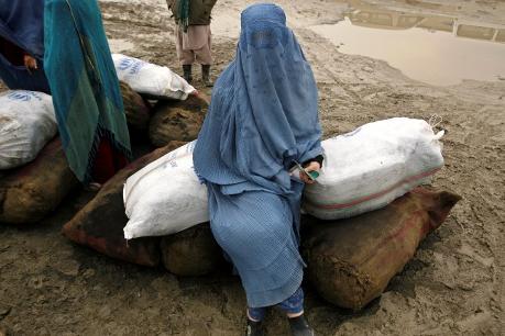 A displaced Afghan woman receives winter aid from the U.N refugee agency in Kabul, Dec. 1, 2009. REUTERS/Omar Sobhani