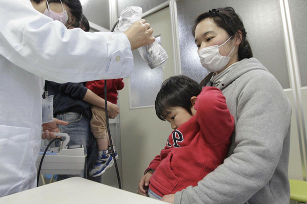 Shunsei Sato sitting on the lap of his mother Maki, from Soma in Fukushima, undergoes a screening test for signs of nuclear radiation by a doctor at a welfare center in Yonezawa, 98 kilometres from the Fukushima nuclear plant. The mother, her son and the rest of the family did not show harmful levels of radiation. Doctors are warning that pregnant women should stay indoors and avoid eating fresh produce or milk after studies have shown even small doses of radiation can harm fetuses.