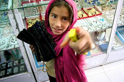 Girl in Kabul selling candy and scarves in market