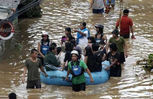 Volunteers use rubber a boat to ferry residents to safer grounds following a flash flood that inundated Cagayan de Oro city, Philippines, Saturday, Dec. 17, 2011. A tropical storm triggered flash floods in the southern Philippines, killing scores of people and missing more. Mayor Lawrence Cruz of nearby Iligan said the coast guard and other rescuers were scouring the waters off his coastal city for survivors or bodies that may have been swept to the sea by a swollen river. Photo: Froilan Gallardo / AP