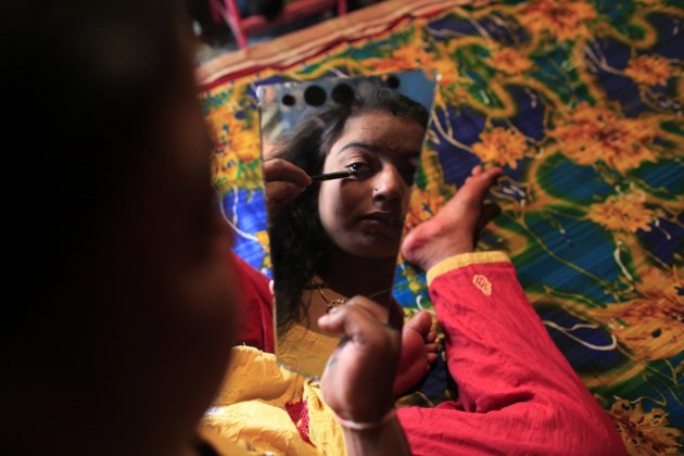 Seventeen-year-old prostitute Hashi applies her makeup as she prepares for customers at Kandapara brothel in Tangail, a northeastern city of Bangladesh