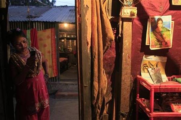 Sixteen-year-old prostitute Maya stands in the doorway of her small room at Kandapara brothel in Tangail, a northeastern city of Bangladesh