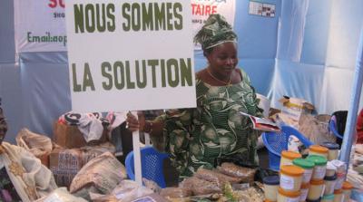 Woman holding a sign in french 'Nous sommes la solution