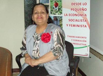 Nora Castaeda, in front of a sign containing one of Banmujers slogans about small-scale loans in a socialist, feminist economy. Credit: Ral Lmaco/IPS