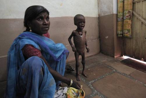 Rajni waits with her mother at the clinic in central India