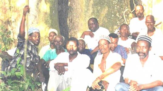 Wanjala Wafula (seated, back centre) and Edwin Webala of Coexist Initiative meet Kaya elders at Kaya Charo in Malindi, Kenya