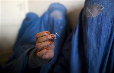 An Afghan woman holds up opium as she attends a counseling session at the Nejat drug rehabilitation centre, an organisation funded by the United Nations providing harm reduction and HIV-AIDS awareness, in Kabul January 29, 2012. With little funding and no access to substitution drugs such as methadone, treatment is rudimentary at Nejat for a problem that is growing in a dirt-poor country riven by conflicts for more than three decades. Opiate consumption in Afghanistan, where it has long been a medication but in recent years has been used increasingly for recreation, is also on a sharp rise. Nejat estimates around 60,000 women in Afghanistan regularly take illegal drugs, including hashish and marijuana. Shrouded in stigma, female drug users is a topic that is almost never mentioned in Afghanistan. Picture taken January 29, 2012. REUTERS-Ahmad Masood