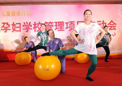 Several pregnant women demonstrate prenatal exercises at the ceremony. [Xinhua]