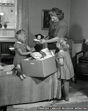 Mother and daughters look at a pack from 1947