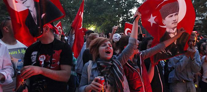 Turkish protesters wave national flags with portraits of Turkey's founder Kemal Ataturk as they take part in an anti-government rally on Sunday, June 9, 2013.