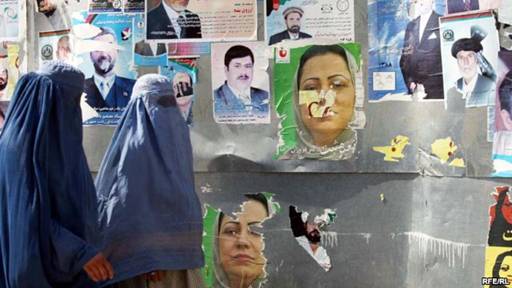 Two Afghan women in Kabul walk past posters of presidential and provincial candidates ahead of elections in 2009.