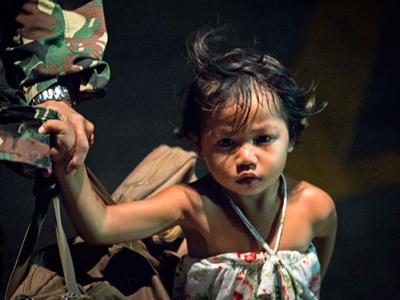 A Filipino girl waits to be airlifted from Tacloban to Manila