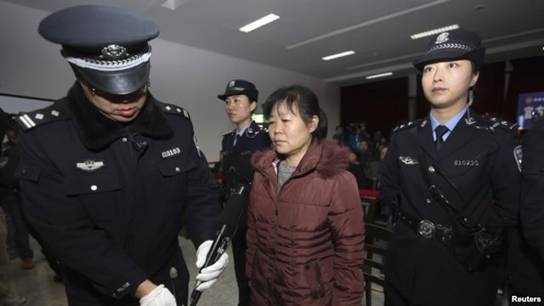 FILE - Zhang Shuxia, an obstetrician involved in baby trafficking, stands trial in Weinan Intermediate People's Court in Weinan, Shaanxi province. 
