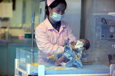 A nurse looks after a rescued baby in a hospital in Xichang, southwest China's Sichuan province. Police have detained two officials in China's latest crackdown on child-trafficking that has ensnared 355 suspects, state media said Dec. 26, 2012.