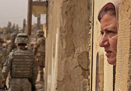 woman looks out of her door in Iraq
