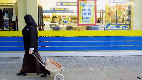 A Muslim woman passes a shop on 10 October 2001 in Berlin's heavily-Muslim Neukoelln district. 