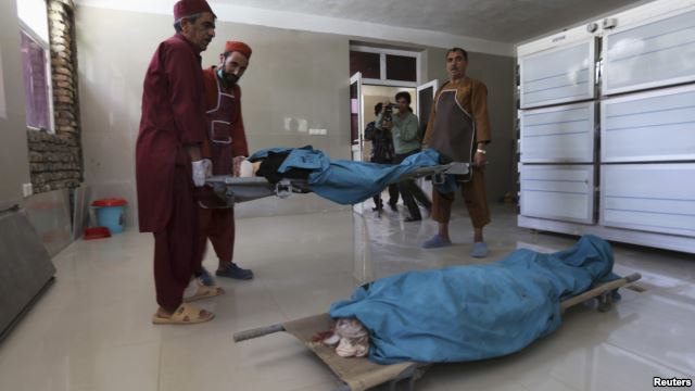 Afghan medical workers carry the bodies of two foreign women who were shot dead in Herat on July 24. 