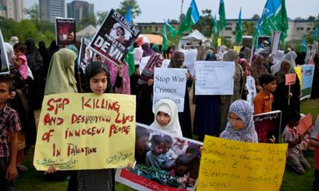 Islamabad, Pakistan: Women and children carry signs calling on Israel to stop the killing in Gaza