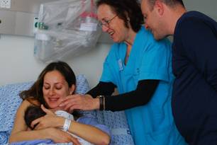 Midwife helps a new mother with her baby - c. Jessica Alderman