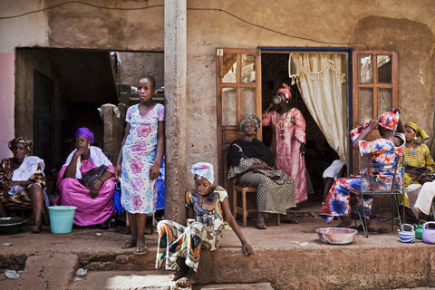 Women sat outside the bride's family home during a rare moment of calm at a wedding celebration in Bamako.