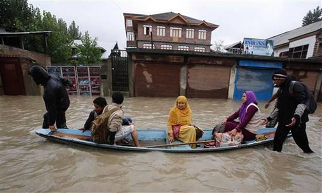 Residents leave a flooded neighborhood on a boat in Srinagar, India, Thursday, Sept. 4, 2014. Authorities say heavy rains have triggered floods and landslides in the Indian portion of Kashmir, killing at least 14 people in the worst flooding in 22 years.