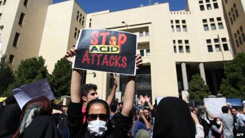 An Iranian woman, hiding her face so as not to be identified, raises a placard during a protest to show solidarity with the acid-attack victims, in front of the judiciary building in Isfahan on October 22.