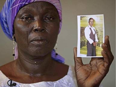 In this May 19, 2014 file photo, Martha Mark, the mother of kidnapped school girl Monica Mark, cries as she display her photo in the family house, in Chibok, Nigeria. 