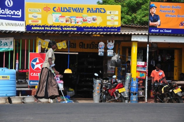 A woman on crutches walks past a row of shops in northern Sri Lanka, where over 110,000 people disabled by war struggle along with very little official assistance. Credit: Amantha Perera