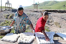  (Two Kyrgyz women lay out balls of salted cottage cheese to dry)  Credit EPA/Igor Kovalenko