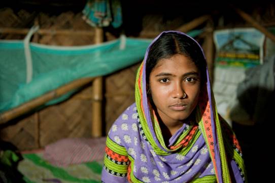 Fatema,15, sits on the bed at her home in Khulna, Bangladesh. Fatema was saved from being married a few weeks earlier. 