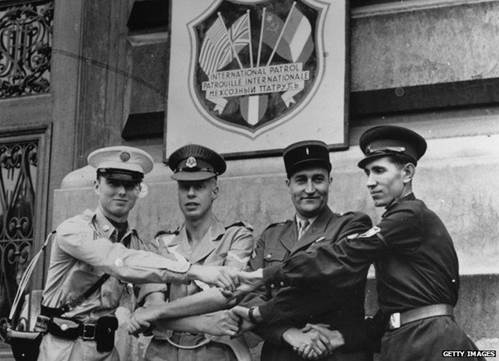 Four soldiers from the Occupying powers shake hands to mark the end of the International Patrol in Vienna.