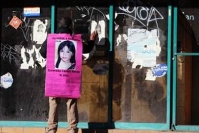 A man carries a photograph of a missing 14-year old girl in Ciudad Juarez