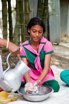 An adolescent girl takes part in an handwashing demonstration for a group of adolescent girls in Chowrapara, Rangpur, Bangladesh.